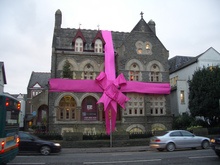 Museum wrapped with large pink ribbon and bow. One of the craft museums included in our craft museum list.