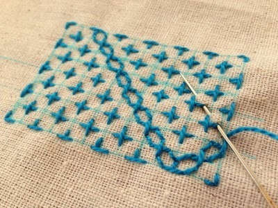 A sample Sashiko stitch on beige linen fabric in blue thread. Looks like little crosses. Great patching technique