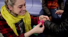 A phot of Yarn Bombing crochet artist London Kaye crocheting in a NYC subway car.