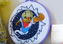 Cross-stitching project of a rocket boy super hero by Emma McKee