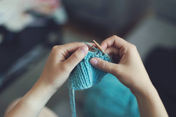 Woman knitting with blue yarn